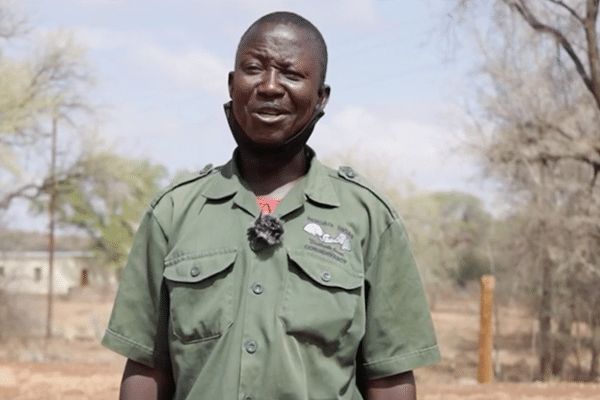 Photo of a man wearing a khaki shirt and facing the camera.